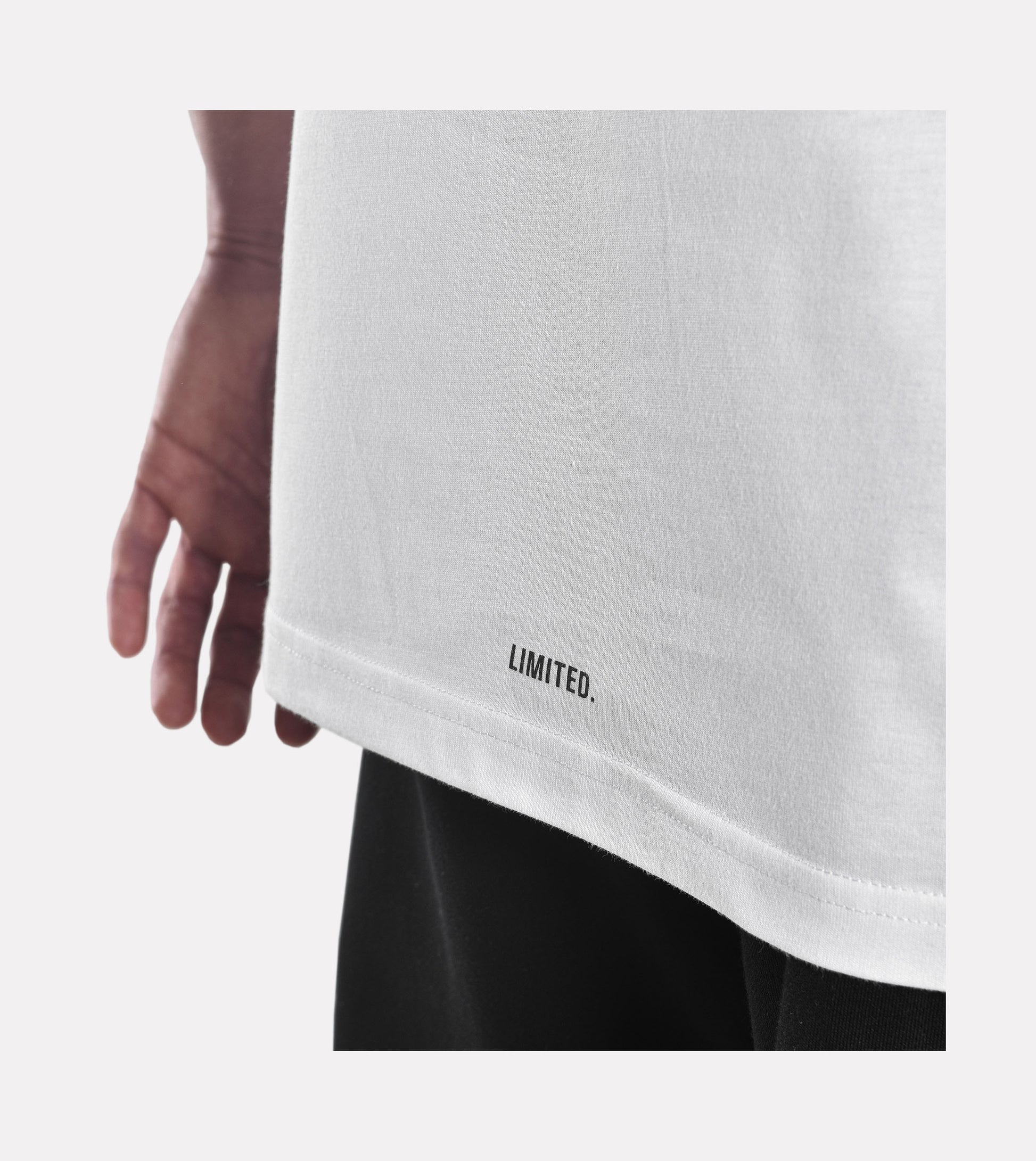 Close-up of model wearing LIMITED. men's infinity white t-shirt showing back branding print detail